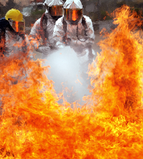 Honorable Mention Photojournalism by LCpl. Christopher O’Quin: Lance Cpl. Kenneth R. Finley and Sgt. Shawn L. Christ, both crash crewmen with MCAS Miramar aircraft rescueand fire fighting, battle a fire that spread to their right side, during a controlled burn aboard the station April 30. The firesgrew up to 20 feet high with temperatures exceeding 1,000 degrees. 