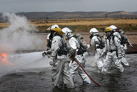 Honorable Mention Photojournalism by LCpl. Christopher O’Quin: MARINE CORPS AIR STATION MIRAMAR, Calif. - Marines with MCAS Miramar Aircraft Rescue and Fire Fighting smother the last of the flames during a controlled burn at a fire pit aboard the station April 30. For the training, the Marines extinguished fire after fire trudging through water saturated with jet fuel. As a safety precaution, Marines manning four firetrucks were prepared to put out the fire at a moments notice.