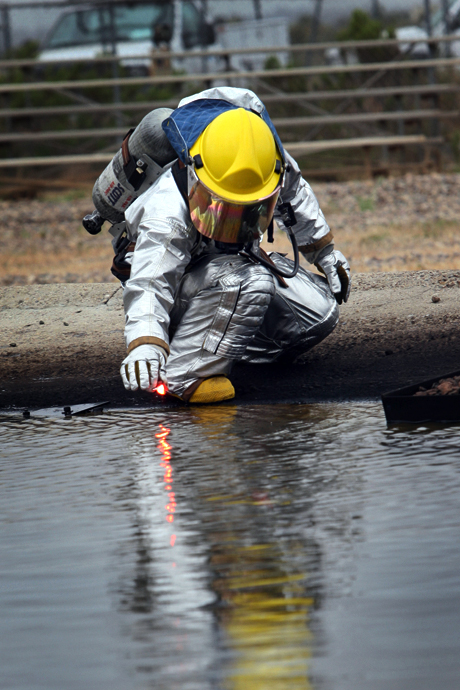 Honorable Mention Photojournalism by LCpl. Christopher O’Quin: MARINE CORPS AIR STATION MIRAMAR, Calif. - A safetyman with MCAS Miramar Aircraft Rescue and Fire Fighting prepares to start one of the last fires for a controlled burn aboard the station, April 30. A pump saturated the water with jet fuel to give the crash fire rescuemen the opportunity to train with the blaze. 