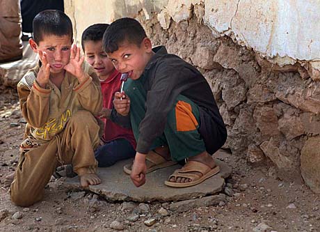 Open Photography Honorable Mention - Sgt. George Papastrat: Iraqi children watch as Marines and sailors with 3rd Marine Aircraft Wing (Forward) visit their village during a humanitarian visit JUne 12, 2008.  Harwan, Iraq is in Al-Anbar and with help from Marines, they recently had their school reconstructed and a well built.